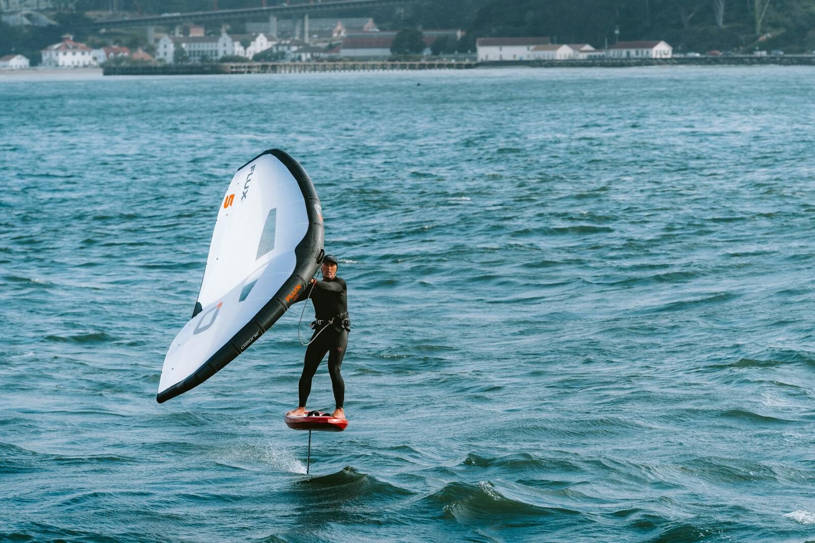 A thrilling scene of a person wing foiling in San Francisco Bay, showcasing the dynamic sport on the water.